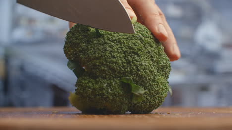Cut-with-a-knife-on-a-wooden-board-closeup-broccoli-in-the-kitchen.-shred